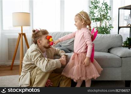 Playful father and daughter enjoy game with clown nose together, family weekend and fatherhood. Playful father and daughter enjoy game together
