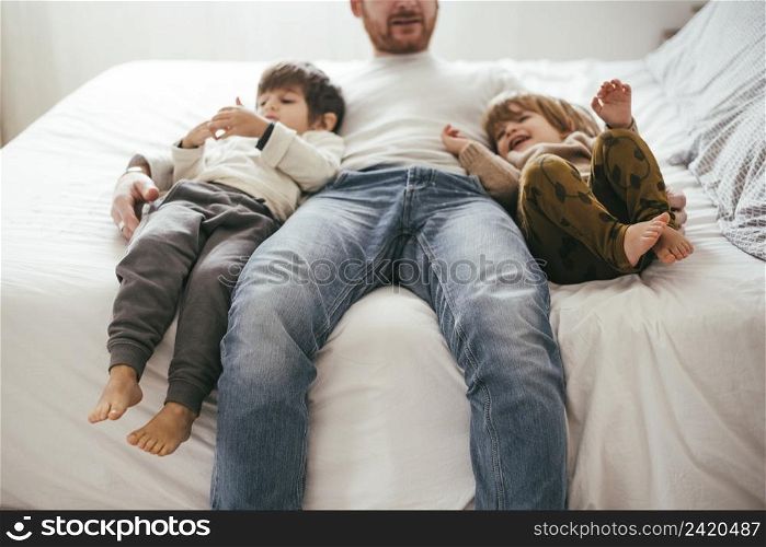 playful father bed with sons