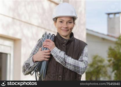 playful female electrician holding cable