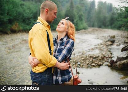 Playful happy handsome couple having while walking in woods. tourists in the mountains. Adventure in nature concept. couple in the mountains. Playful happy handsome couple having while walking in woods. tourists in the mountains. Adventure in nature concept.