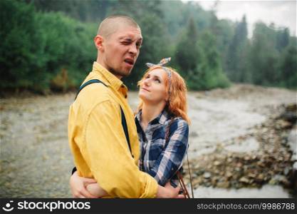 Playful happy handsome couple having while walking in woods. tourists in the mountains. Adventure in nature concept. Playful happy handsome couple having while walking in woods. tourists in the mountains. Adventure in nature concept.