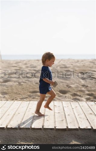playful little boy running beach