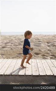 playful little boy running beach