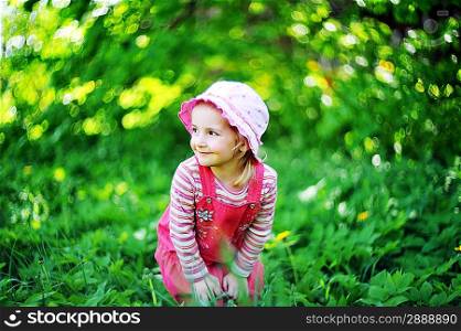 playful little girl in hat on grass. may day