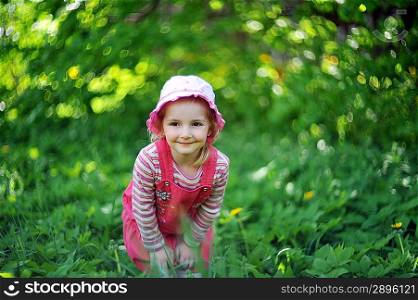 playful little girl in hat on grass. may day