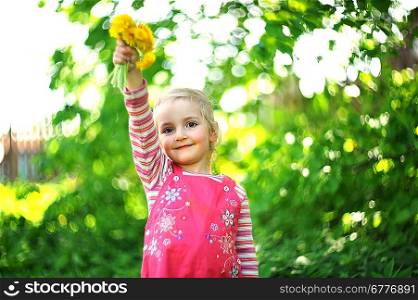 playful little girl in hat with bouquet of dandelions. may day