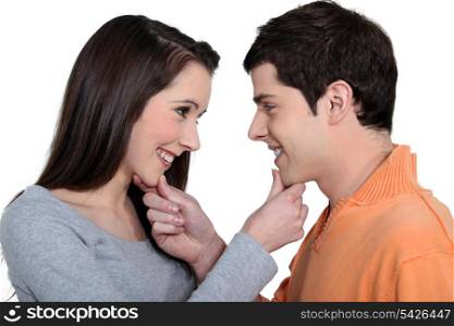 Playful man and woman holding their chin