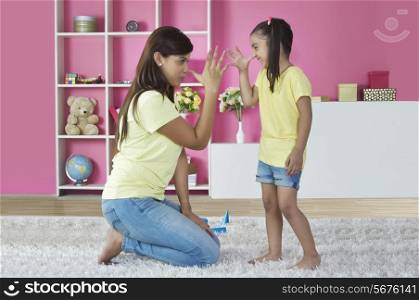 Playful mother and daughter teasing each other at home