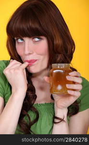 Playful woman eating honey