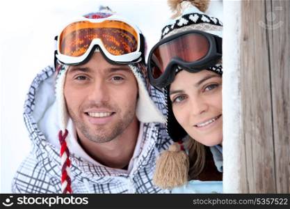 Playful young couple enjoying their skiing holiday
