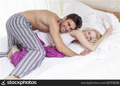 Playful young couple in bed