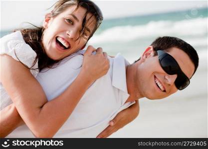Playful young couple sniling on the beach,outdoor