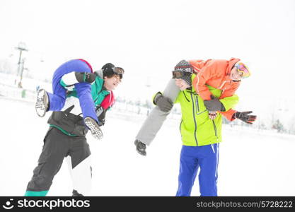 Playful young couples enjoying in snow