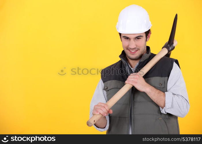 Playful young man holding a pickaxe
