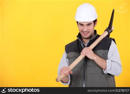 Playful young man holding a pickaxe