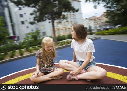 playground. Beautiful girls are riding on a swing. Wroclaw, Poland