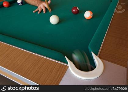 Playing billiards with balls on a green felt table