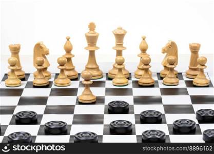 playing by different rules on the same board - black checkers and white chess figures on black white chessboard, pawn and checkers piece move (focus on the pawn)