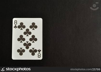 Playing card. Eight of clovers isolated on a black background