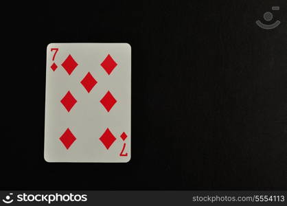 Playing card. Seven of diamond isolated on a black background