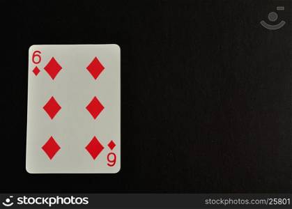 Playing card. Six of diamond isolated on a black background