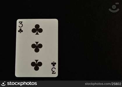 Playing card. Three of clovers isolated on a black background