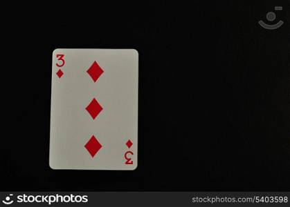Playing card. Three of diamond isolated on a black background