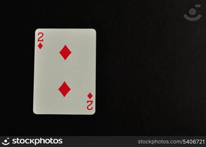 Playing card. Two of diamond isolated on a black background