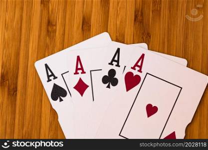 Playing cards aces card close up, isolated on wooden table. Casino concept, risk, chance, good luck or gambling.
