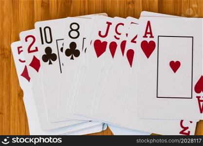 Playing cards close up, isolated on wooden table. Casino concept, risk, chance, good luck or gambling.