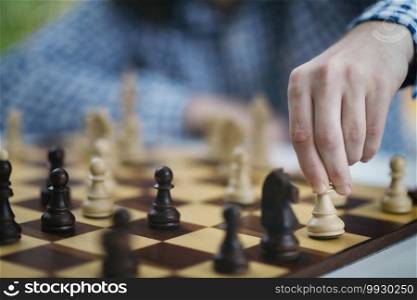 Playing Chess. Hand of a male chess player moving the white chess piece. . Hand of Chess Player Moving the Chess Piece