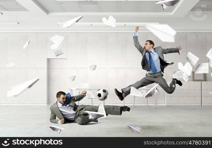 Playing football in office. Business people in suit in modern office play ball