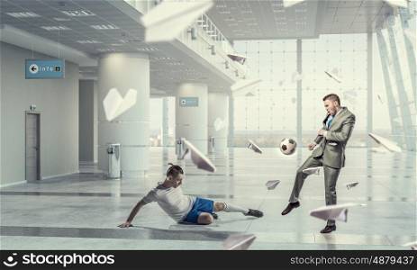 Playing football in office. Business people in suit in modern office play ball