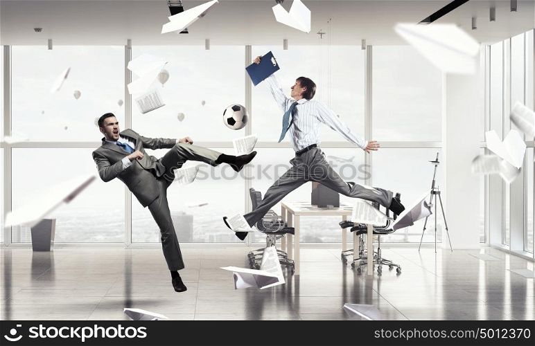 Playing football in office. Business people in suit in modern office play ball