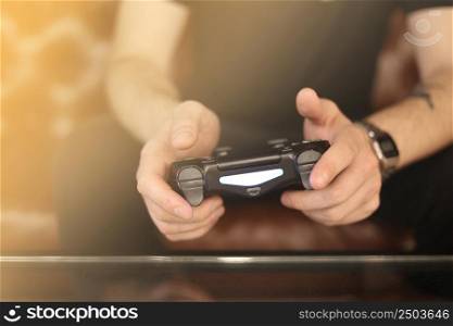 Playing games concept. Part body man with joystick play game on console. Male hands holding pad. High quality photo.. Playing games concept. Part body man with joystick play game on console. Male hands holding pad. High quality photo
