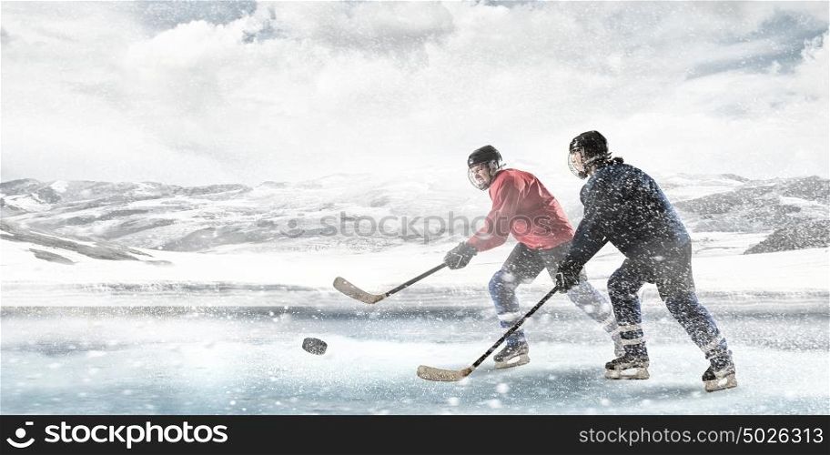 Playing hockey game. Ice hockey players on the ice outdoors