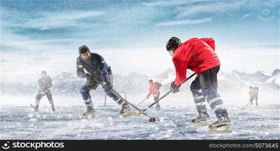 Playing hockey game. Ice hockey players on the ice outdoors
