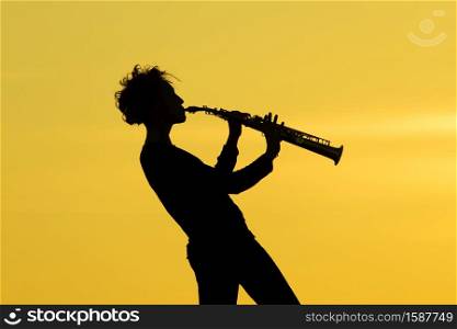 Playing saxophone silhouette on yellow background