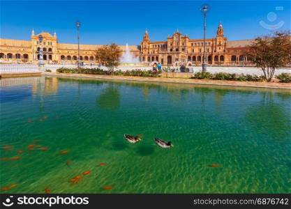 Plaza de Espana at sunny day in Seville, Spain. Spain Square or Plaza de Espana in Seville in the sunny summer day, Andalusia, Spain. Goldfish and ducks in the channel in the foreground