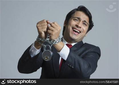 Pleading businessman tied in chain over gray background