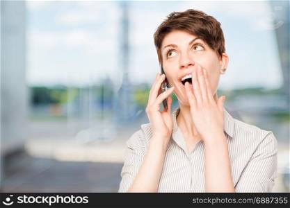 pleasantly shocked woman with mobile phone in the office