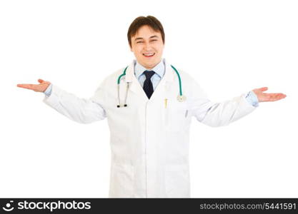 Pleased medical doctor presenting something on empty hands isolated on white&#xA;