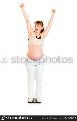 Pleased pregnant woman standing on weight scale isolated on white&#xA;