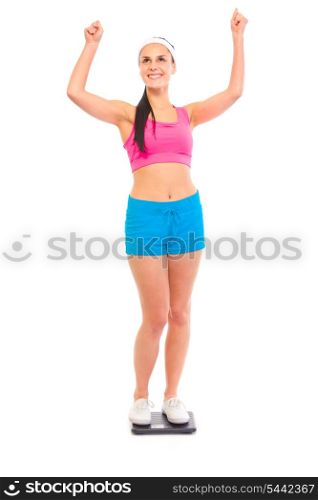 Pleased with her weight young fit girl standing on weight scale isolated on white&#xA;