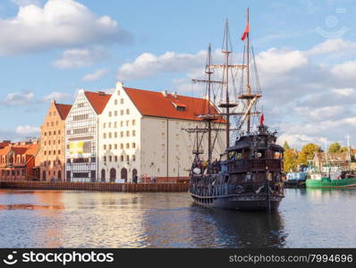 Pleasure craft and colorful facades of the houses on the central waterfront in Gdansk.. Gdansk. Central embankment.