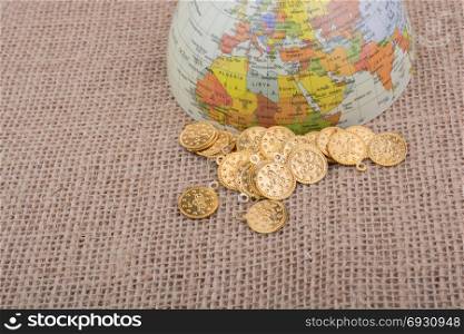 Plenty of fake gold coins beside the globe