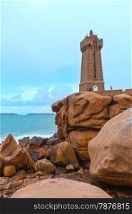 Ploumanach lighthouse (Mean Ruz lighthouse - built in 1946, planned by architect Henry Auffret) and family near (Perros-Guirec, Brittany, France). The Pink Granite Coast.