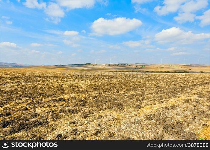 Plowed Fields on the Background of the Modern Wind Turbines Producing Energy in Spain