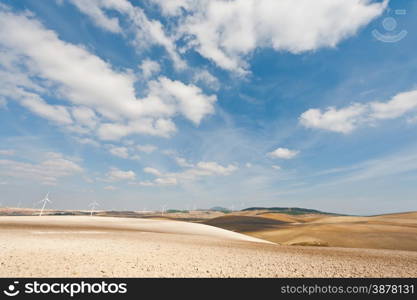 Plowed Fields on the Background of the Modern Wind Turbines Producing Energy in Spain