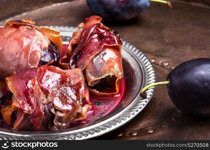 plum baked in jamon. spicy spanish dish jamon with plum on a retro background
